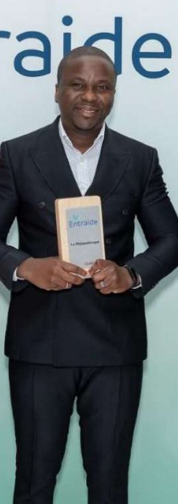 Ulrich Djidonou tenant le prix Le Philanthrope, catégorie Distinction, campagne Entraide 2025